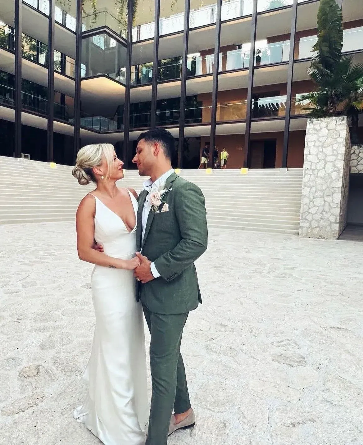 a bride and groom are posing for a picture in front of a building