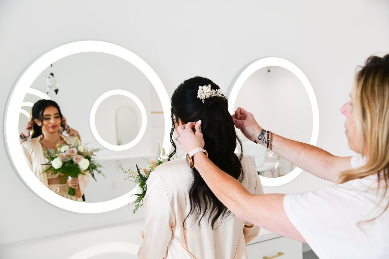 a woman is getting her hair done in front of a mirror