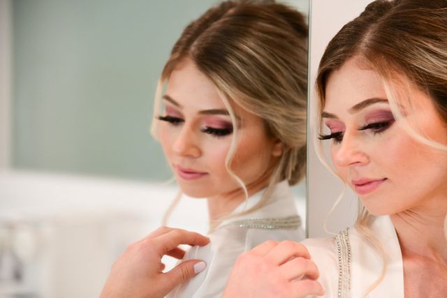 a woman is looking at her reflection in a mirror