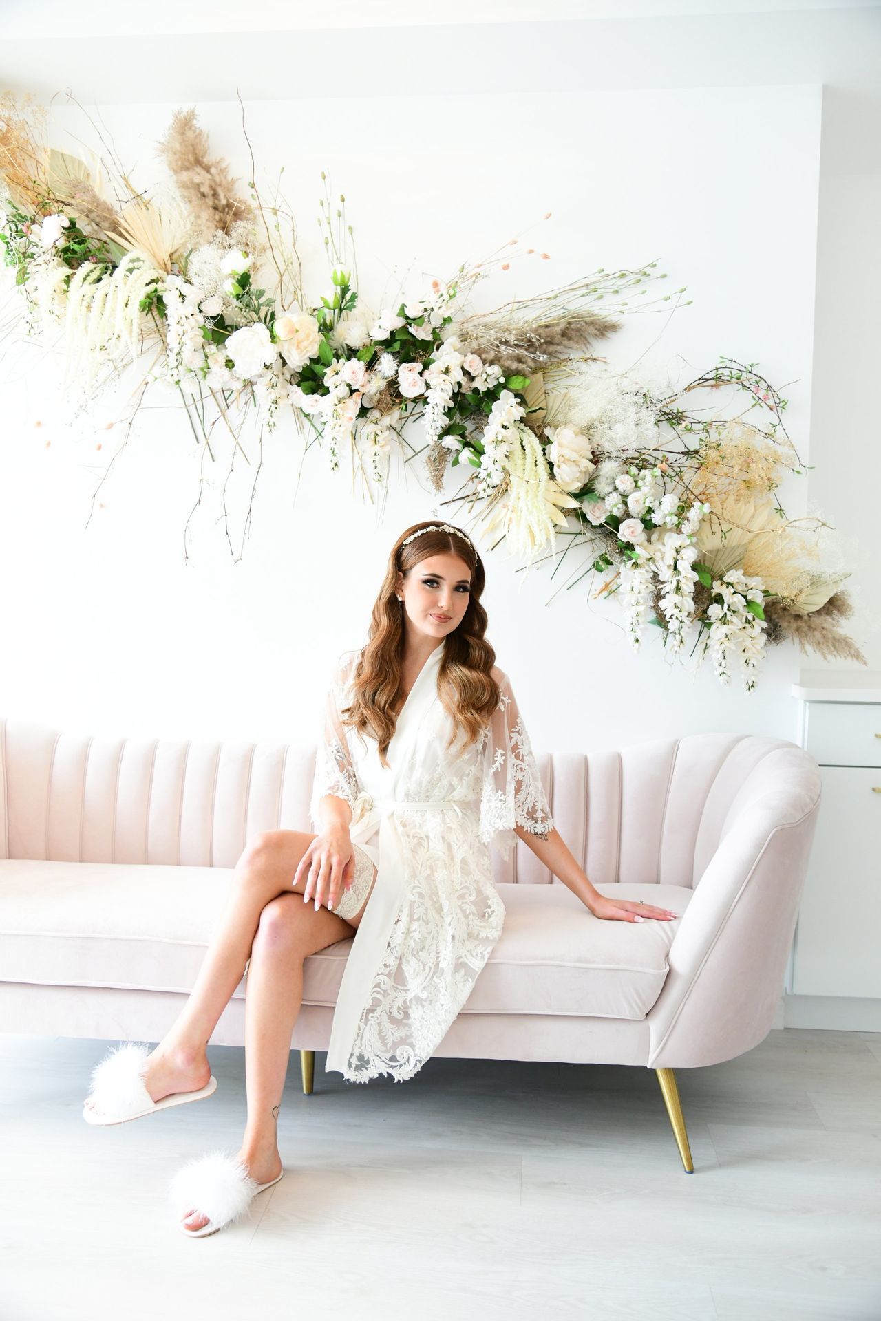 a woman in a white robe is sitting on a pink couch