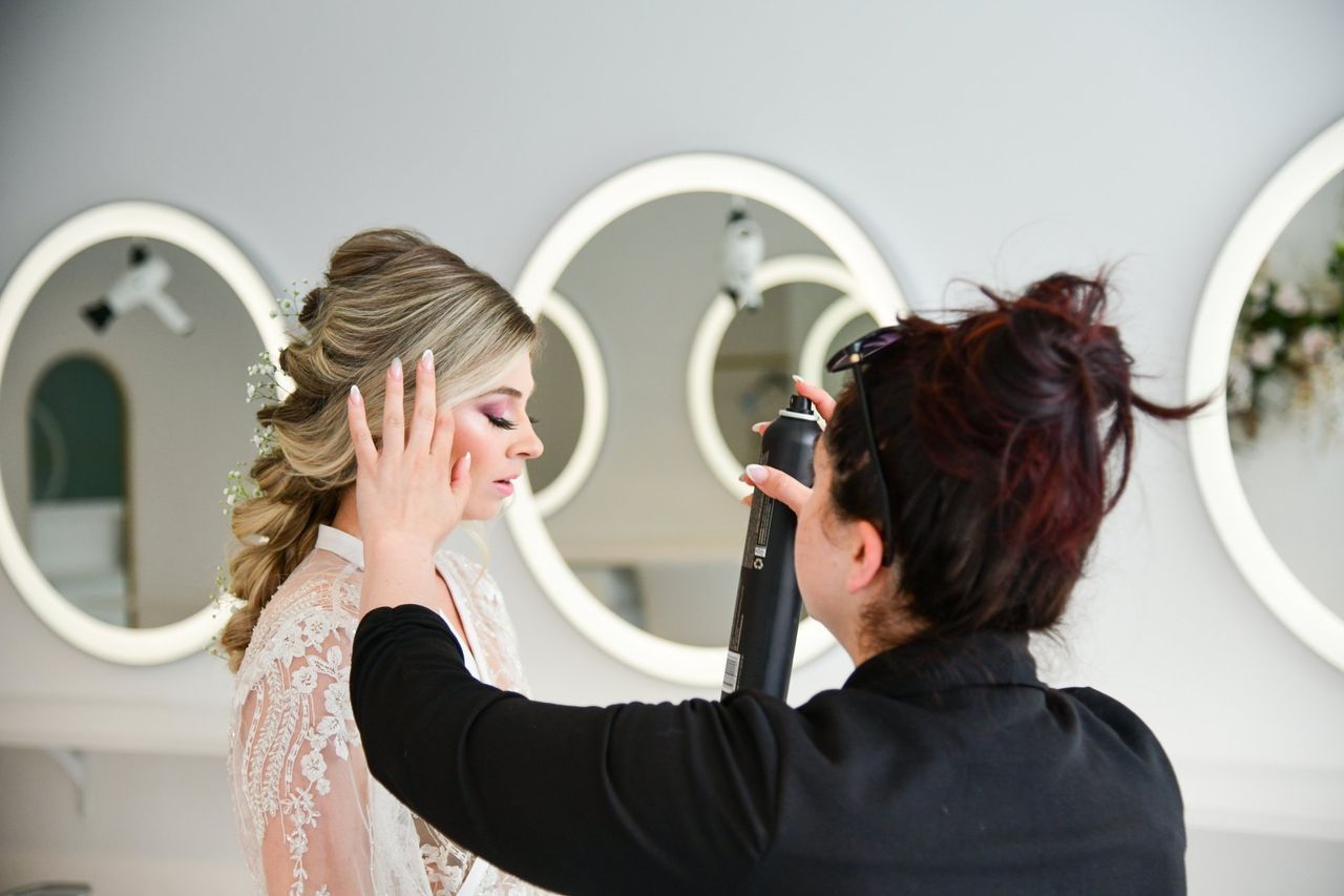 a woman is blow drying a woman 's hair in a salon