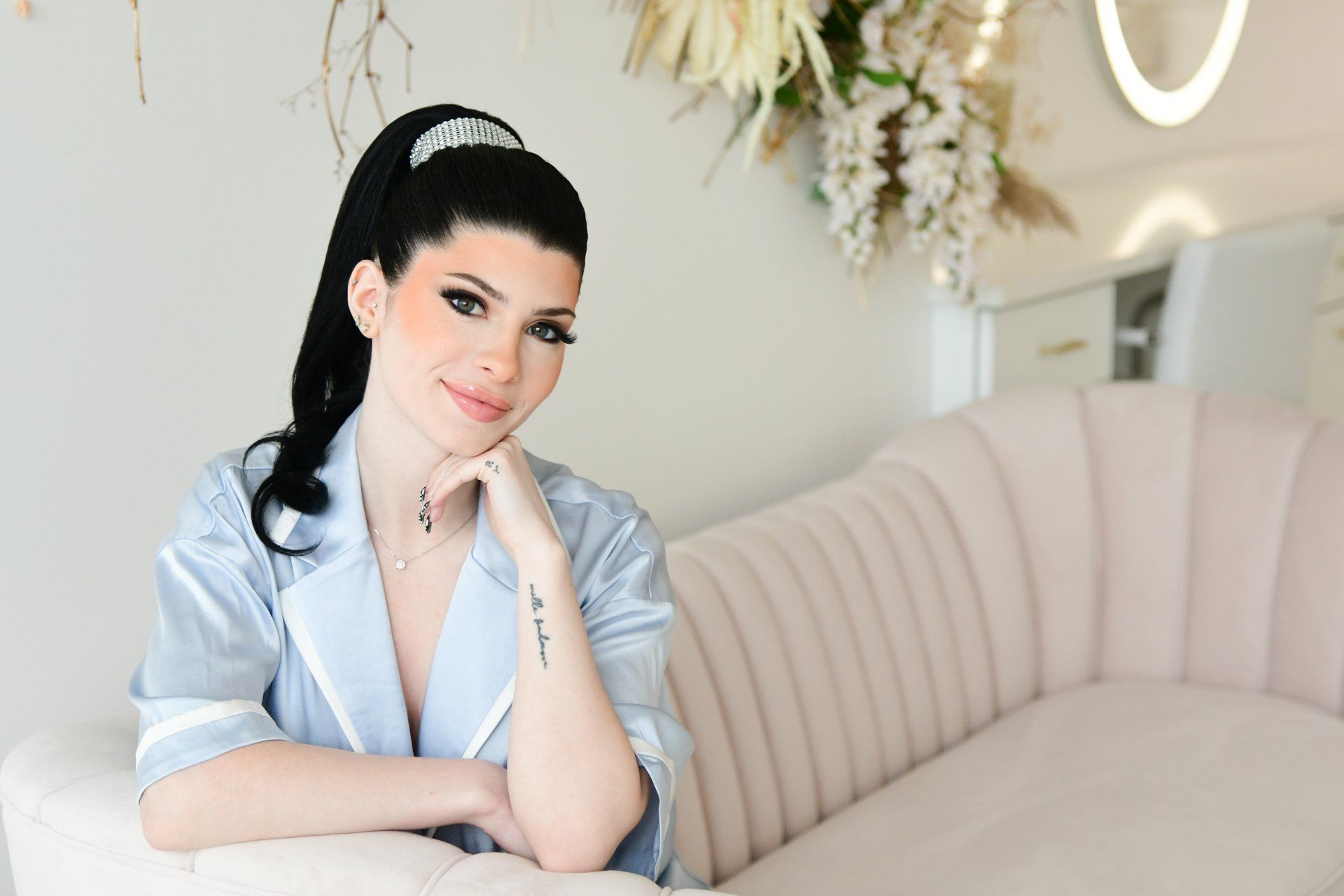 a woman is sitting on a couch with her hand on her chin