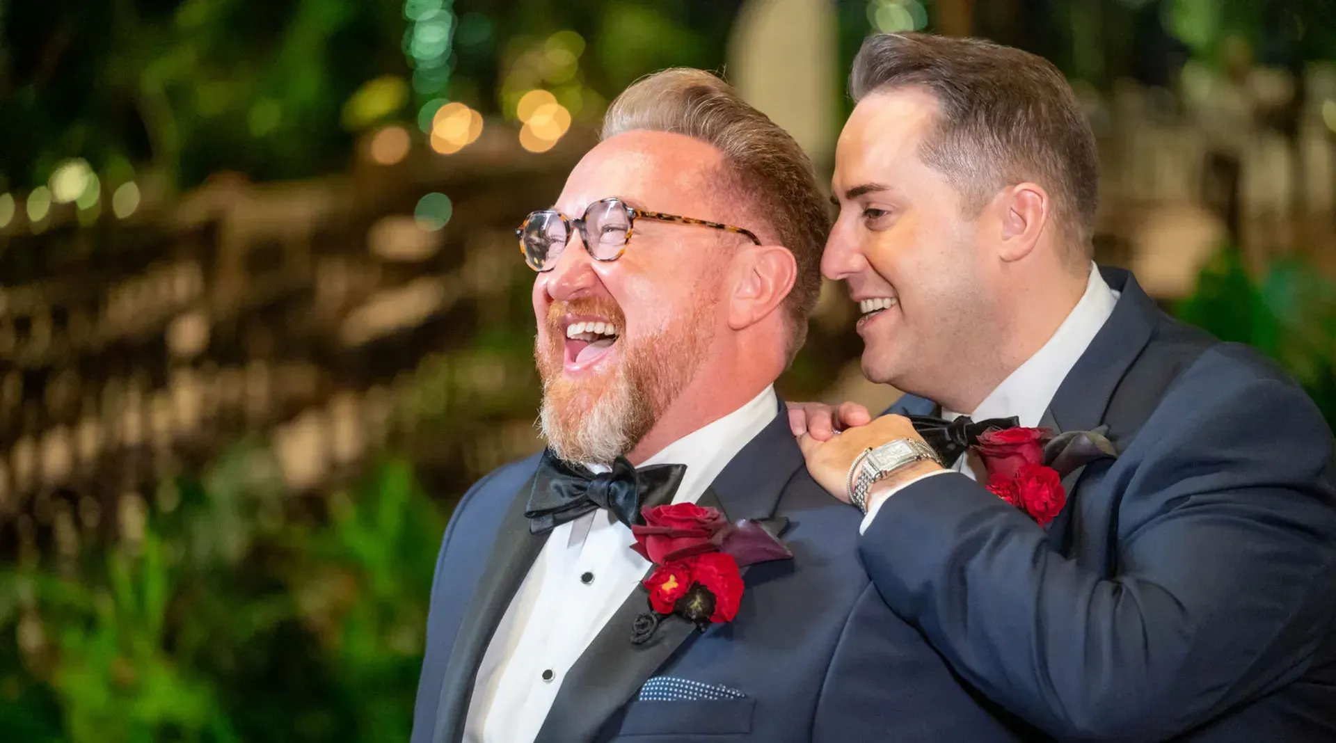 two men in tuxedos are standing next to each other and laughing