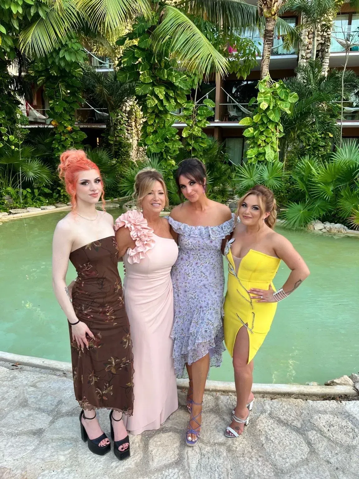 a group of women are posing for a picture in front of a pond