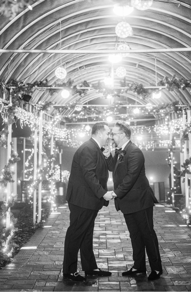 two men in suits are standing next to each other in a tunnel