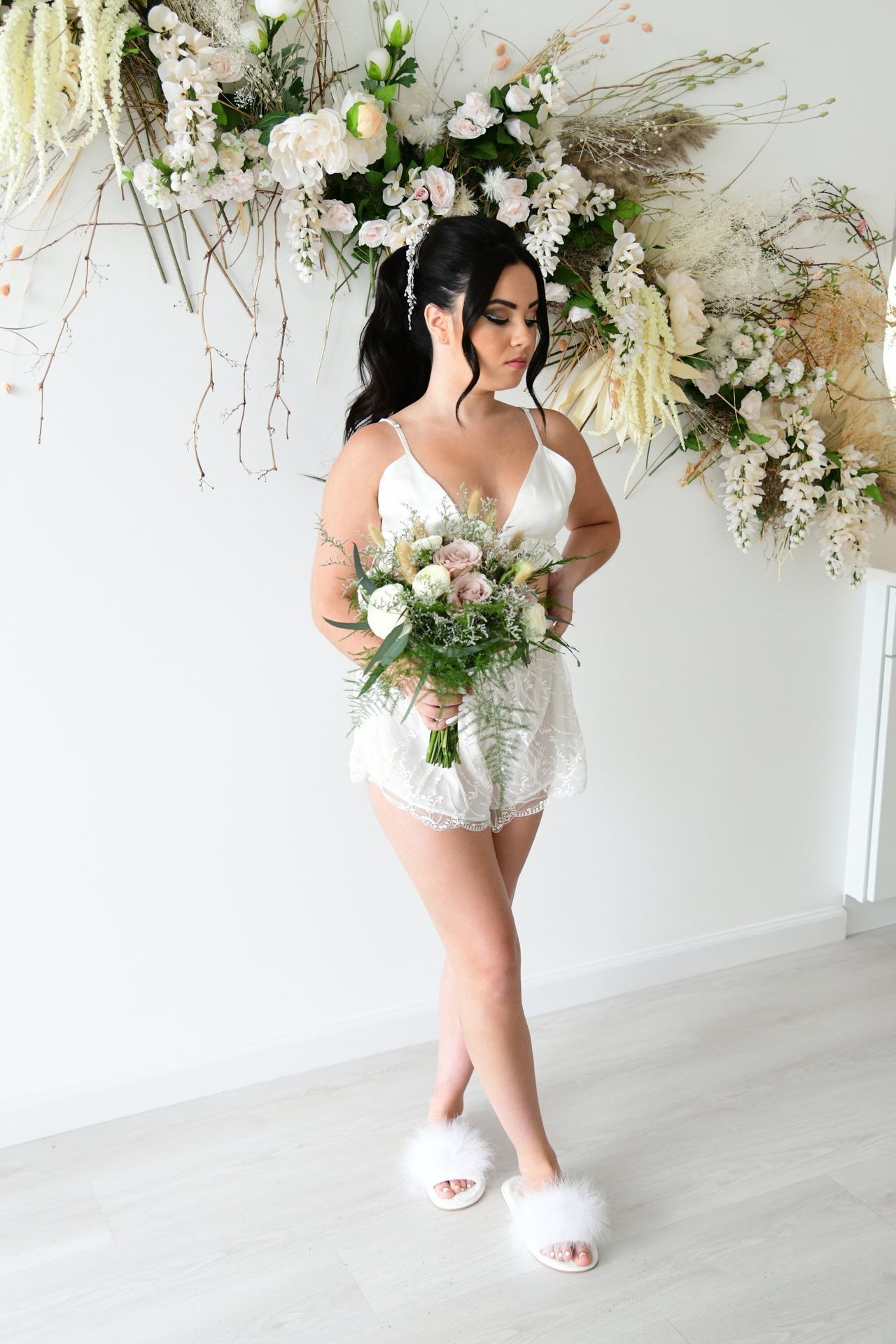 a woman in a white dress is holding a bouquet of flowers