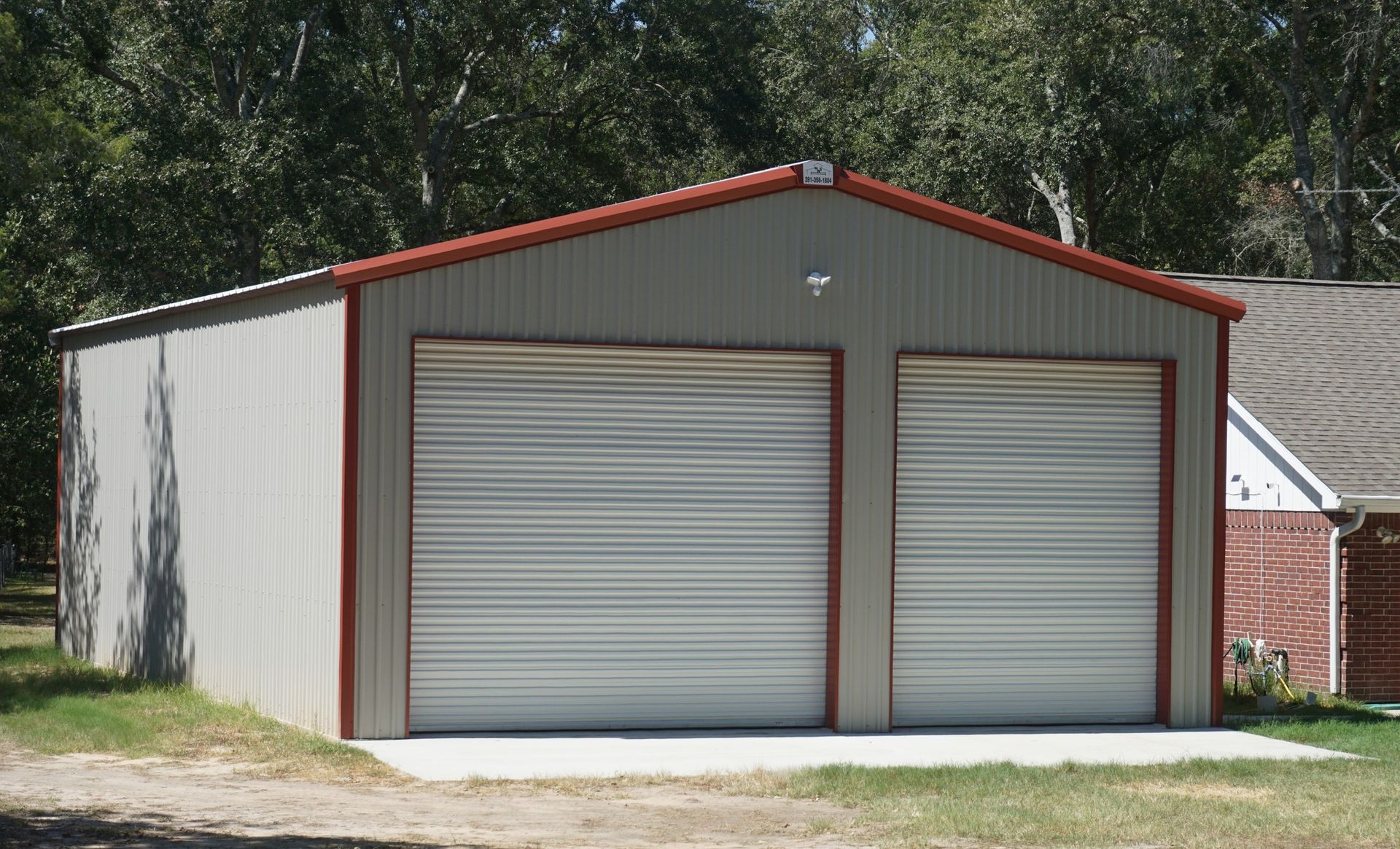 A garage with two garage doors and a red roof