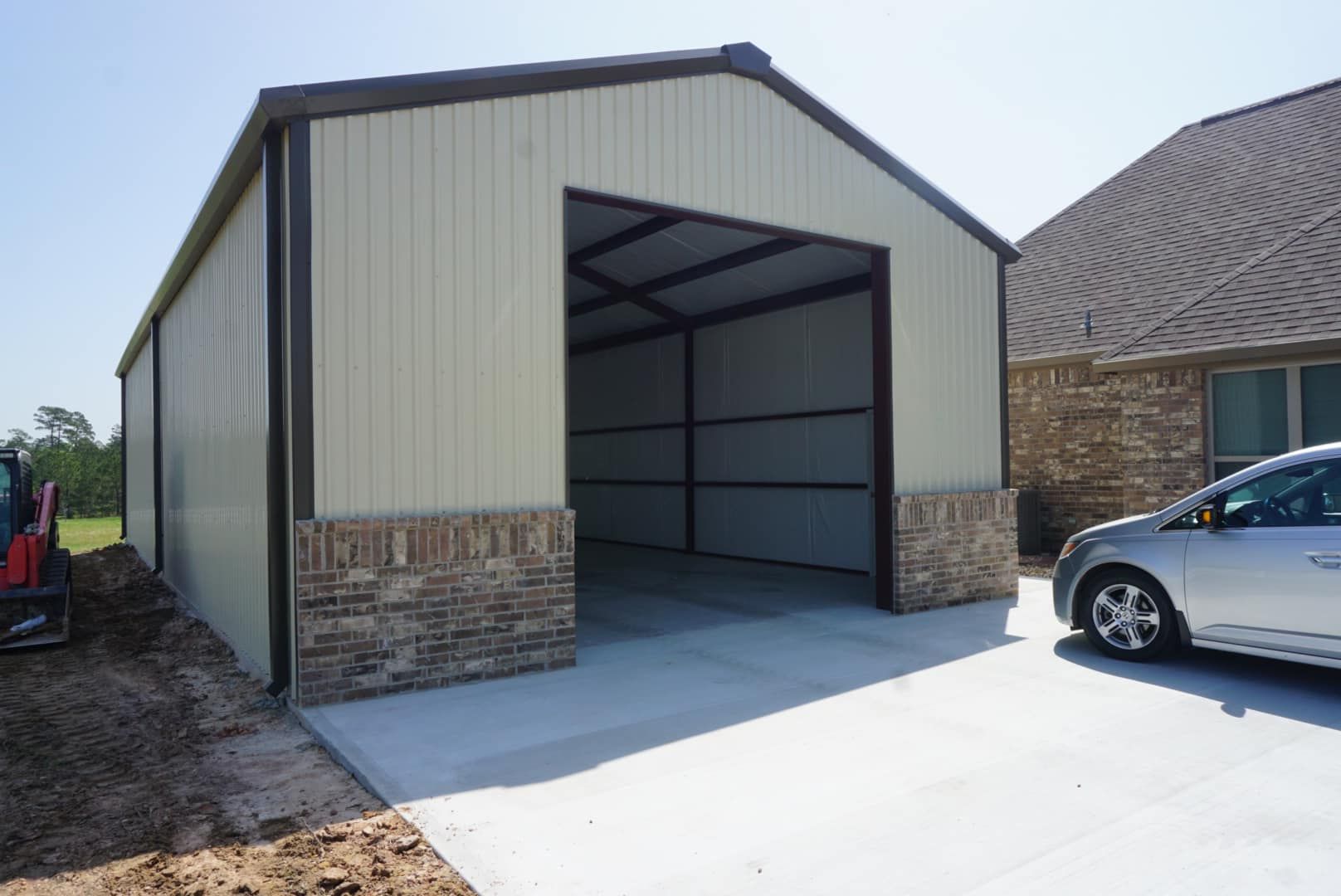 A car is parked in front of a metal garage.