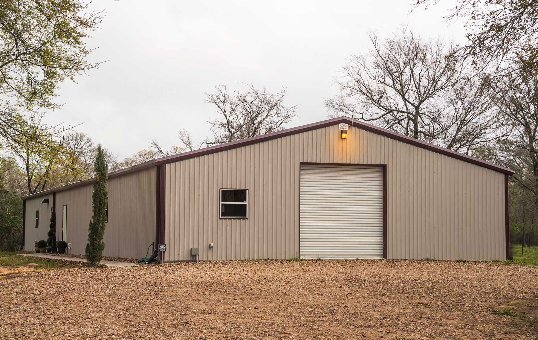 A large metal building with a garage door and a window.