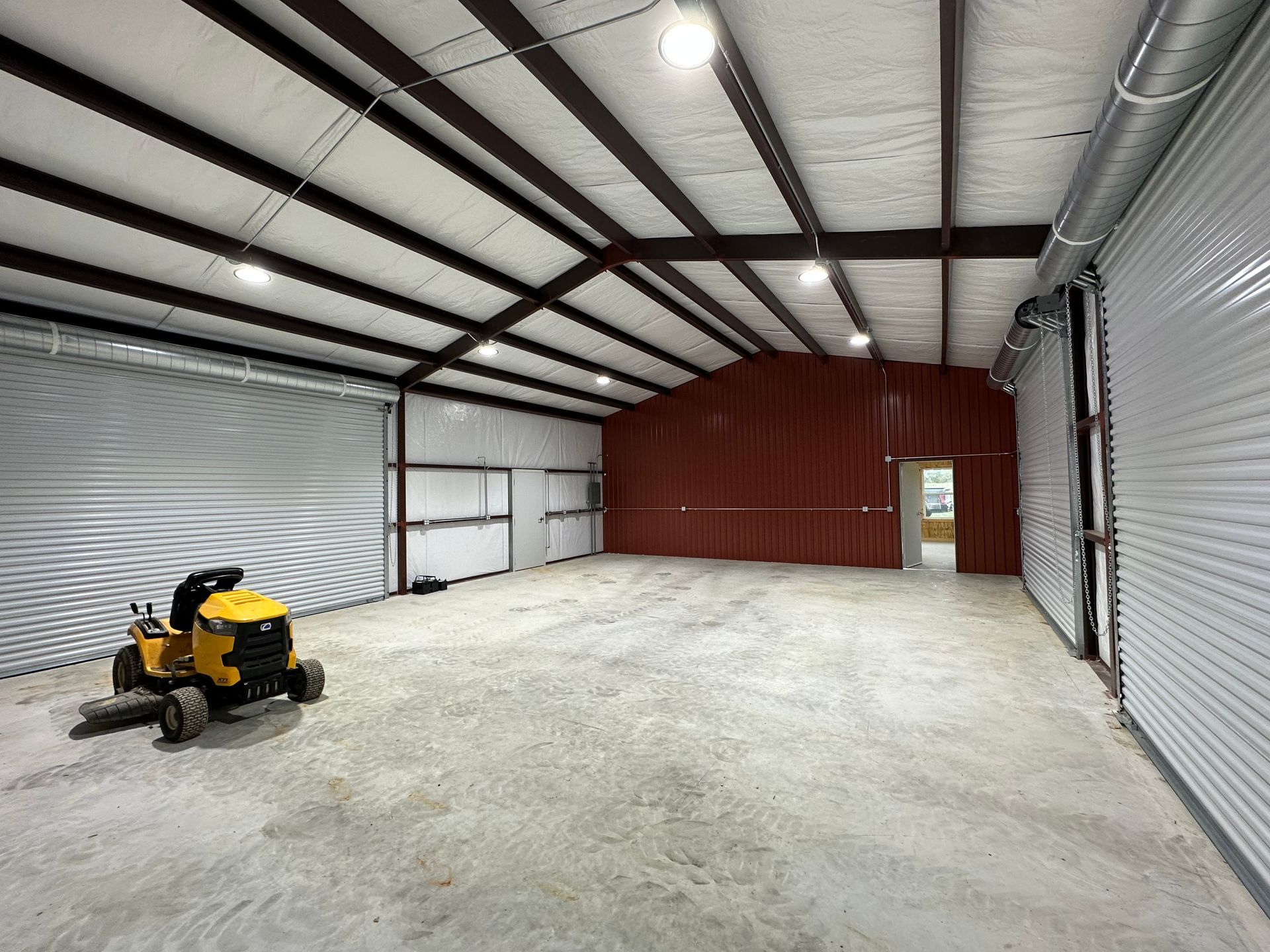 A yellow lawn mower is parked inside
