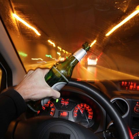 Person driving with beer in hand