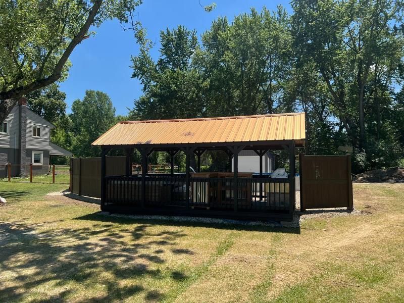 A gazebo is sitting in the middle of a grassy field.