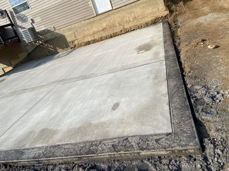 A concrete driveway is being built in front of a house.