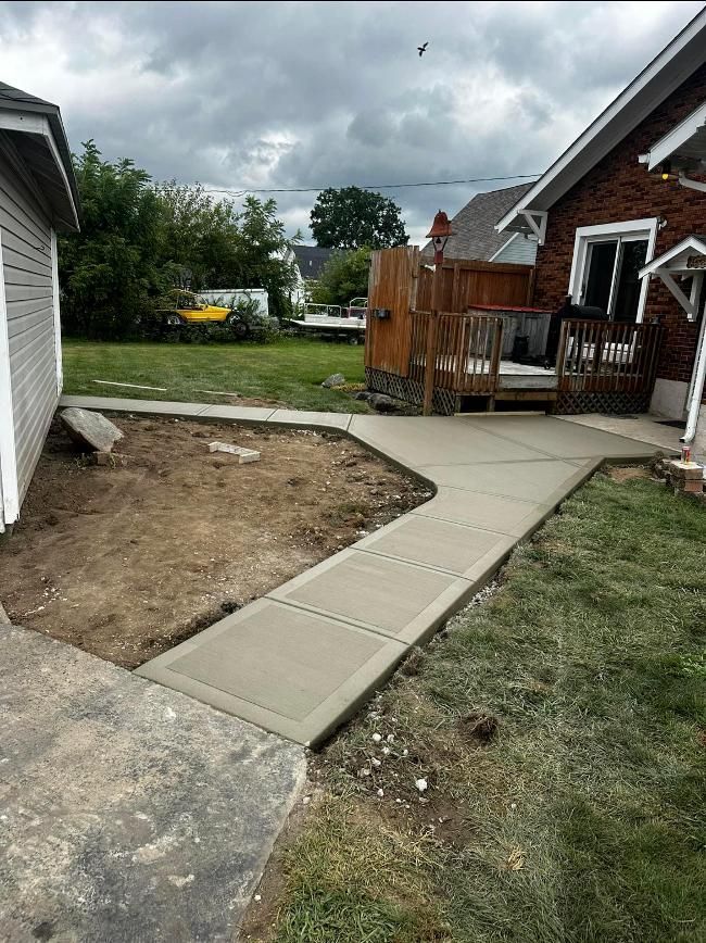 A concrete walkway is being built in front of a house.
