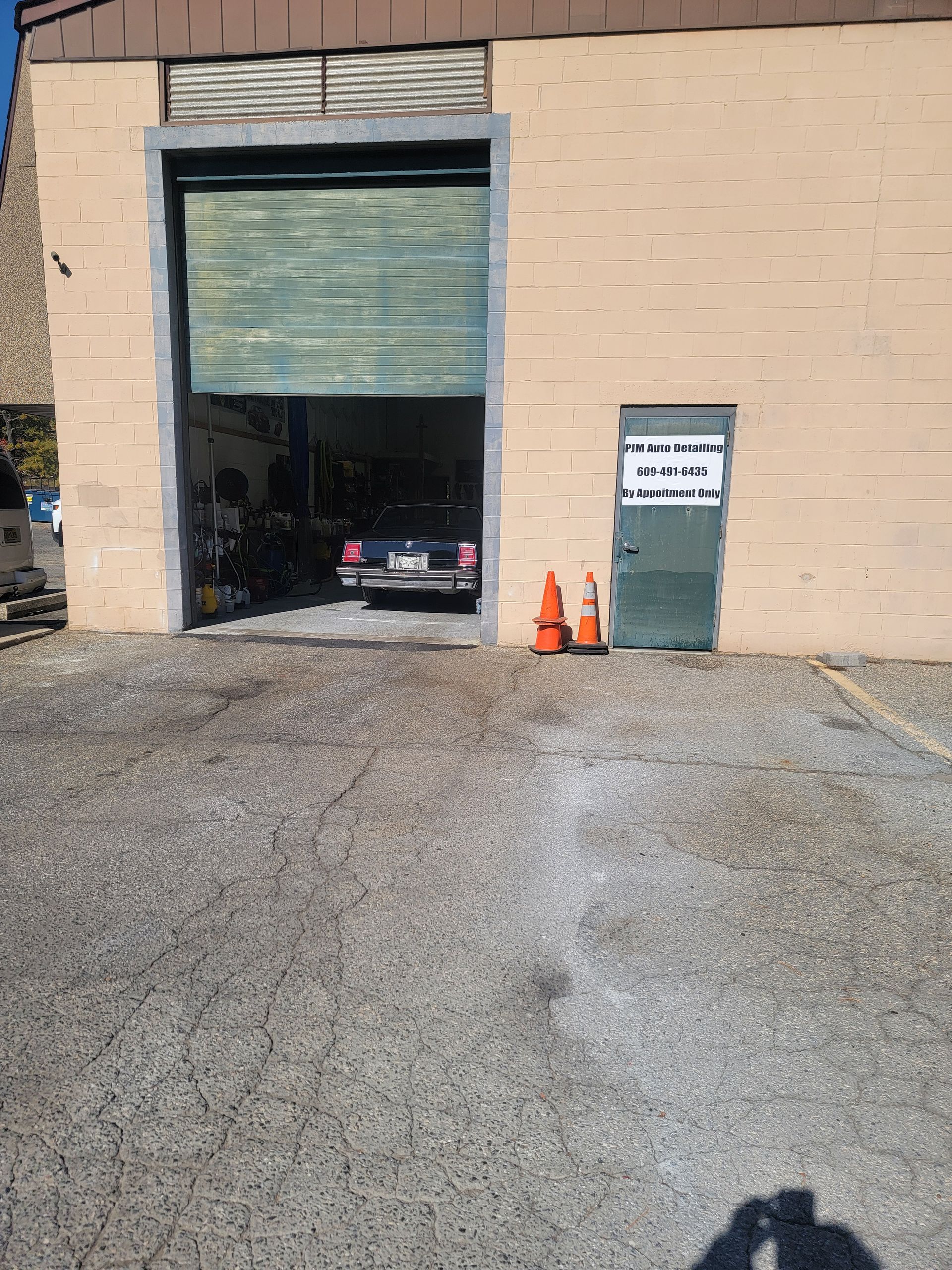 A car is parked in front of a garage door.
