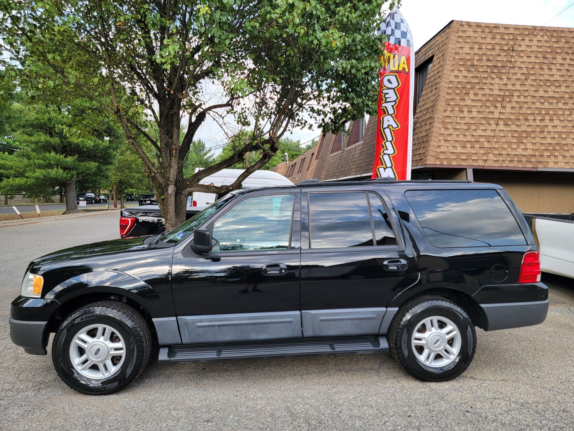 A black ford expedition is parked in front of a building.