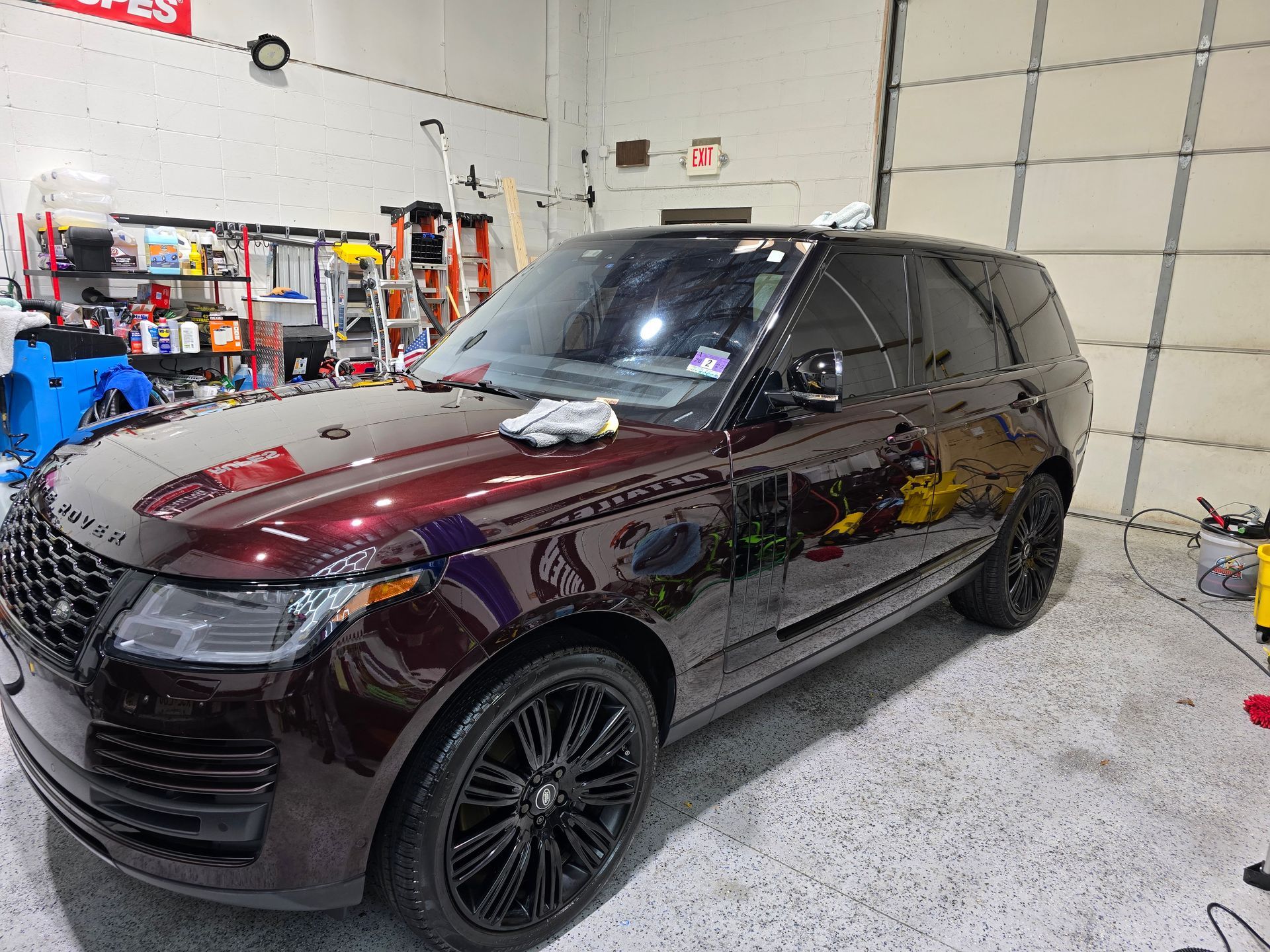 A range rover is parked in a garage next to a garage door.