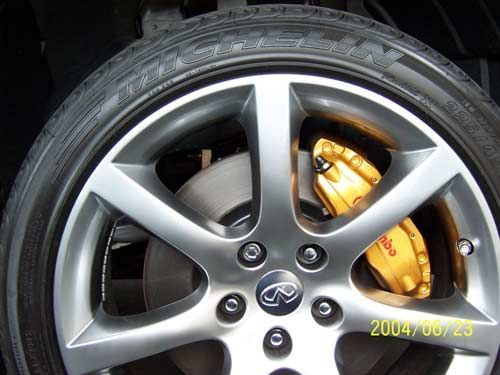 Silver car wheel with yellow Brembo brake calipers.