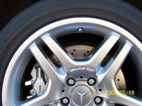 Silver Mercedes AMG rim with brake caliper visible.