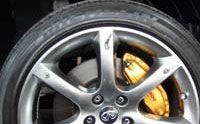 Silver car wheel with a yellow brake caliper.