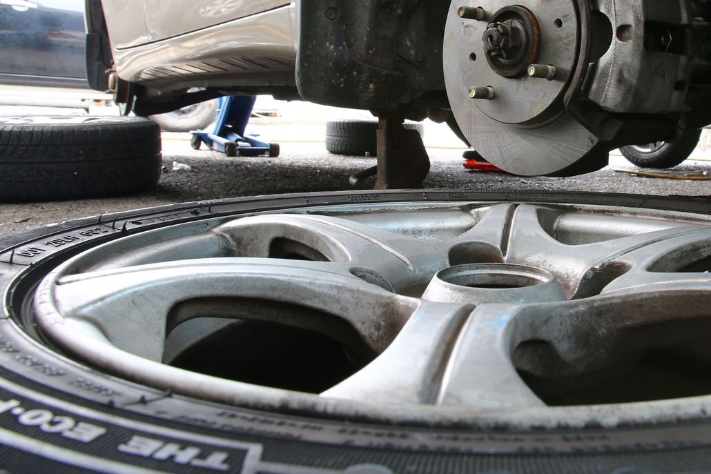Car wheel being machined on a lathe, with metal shavings visible.