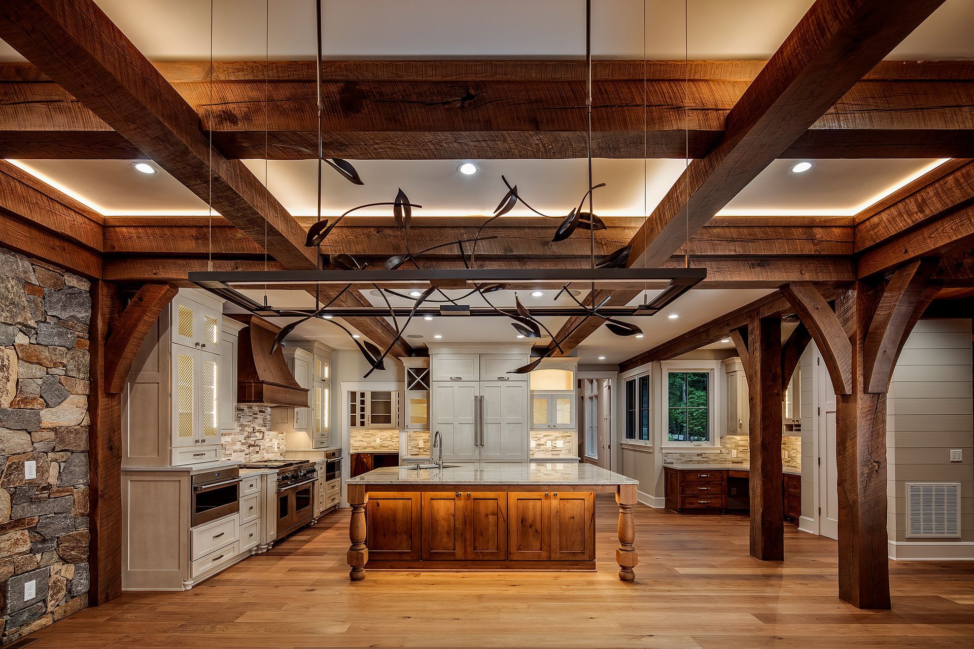 A large kitchen with wooden beams and a large island in the middle.