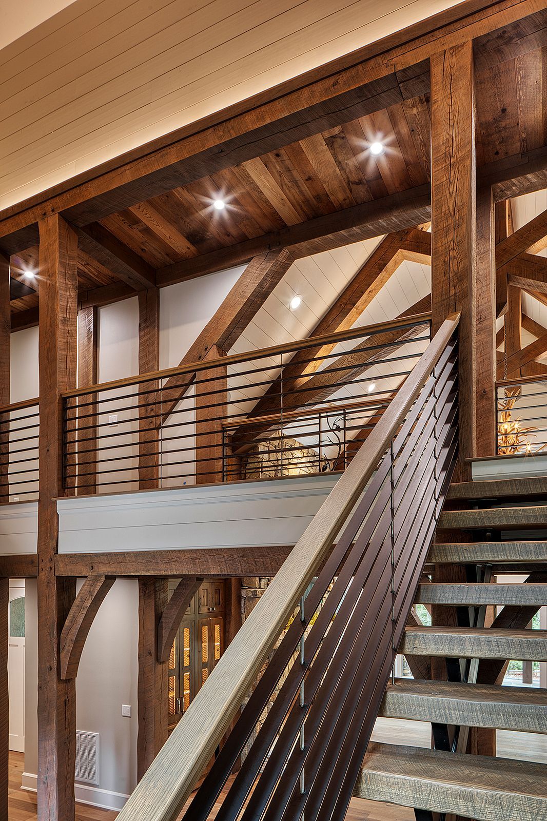 A wooden staircase with a metal railing in a house.