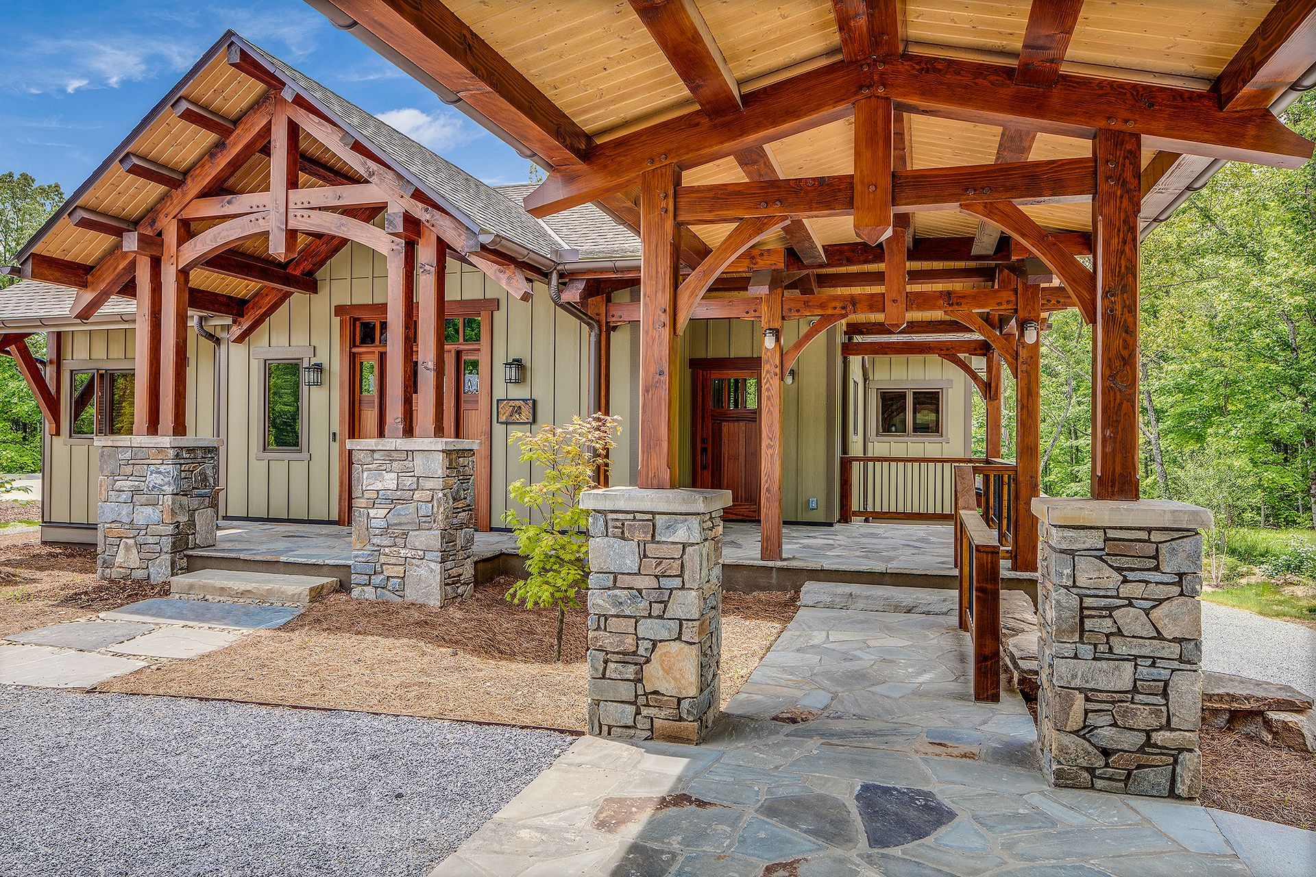 A house with a wooden roof and a stone walkway leading to it.