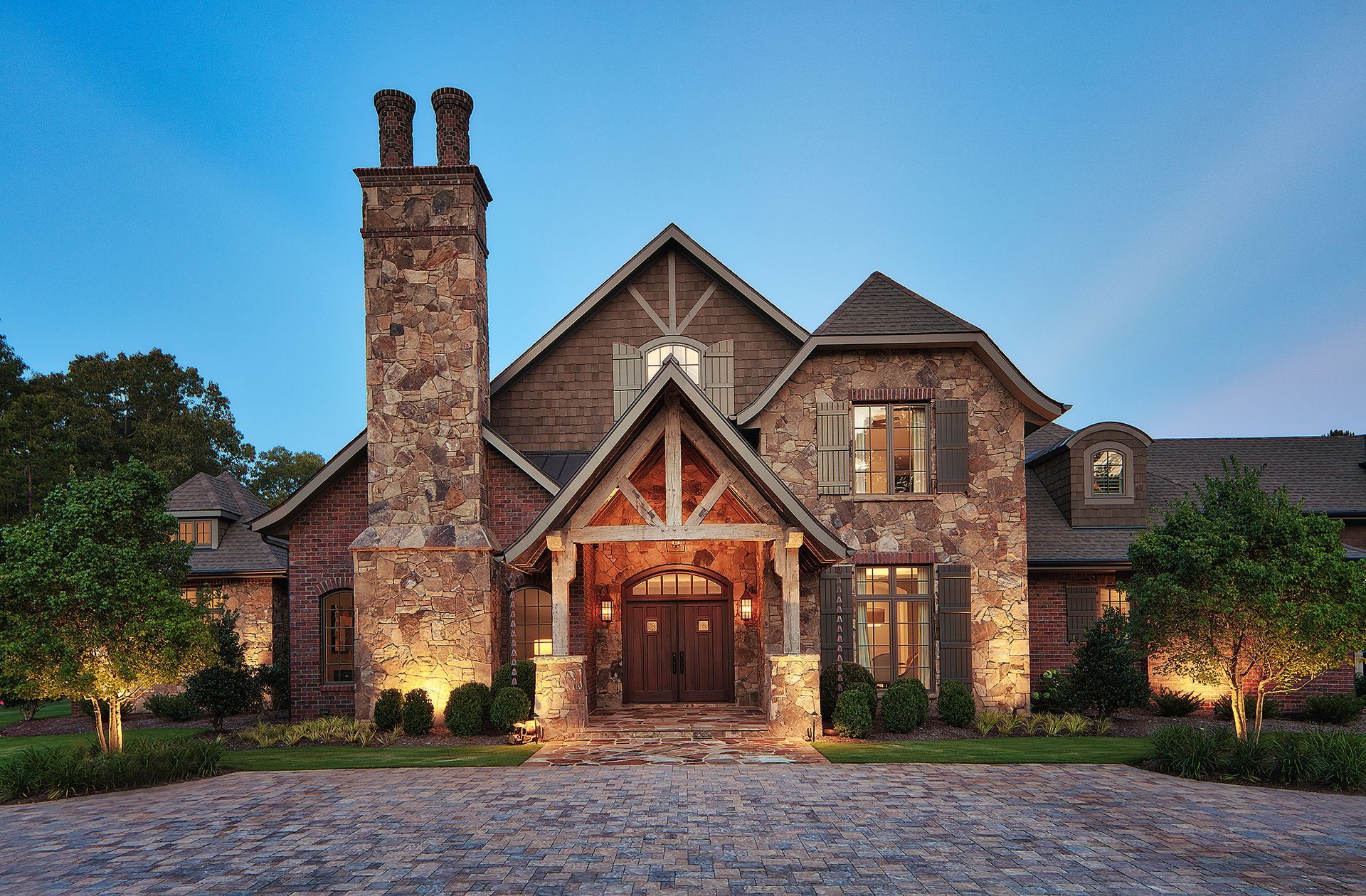 A large stone house with a large chimney on the top of it.