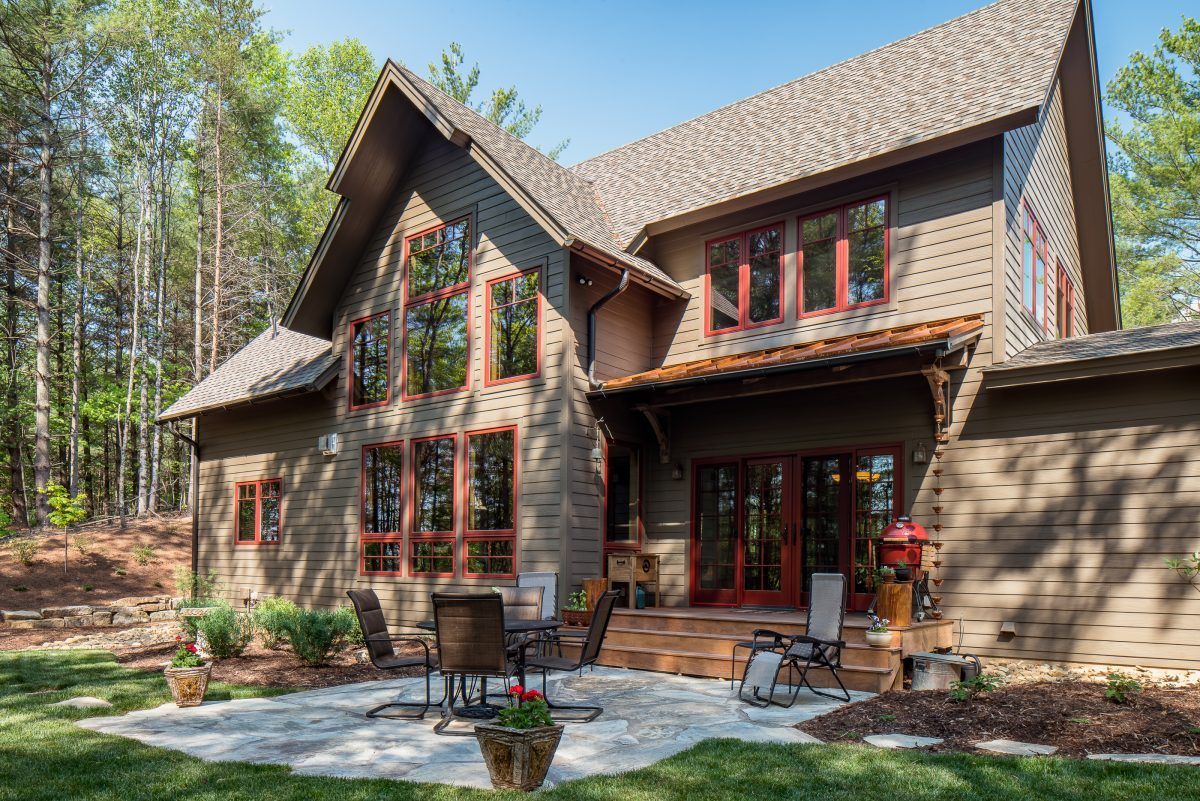 A large house with a lot of windows and a patio in front of it.