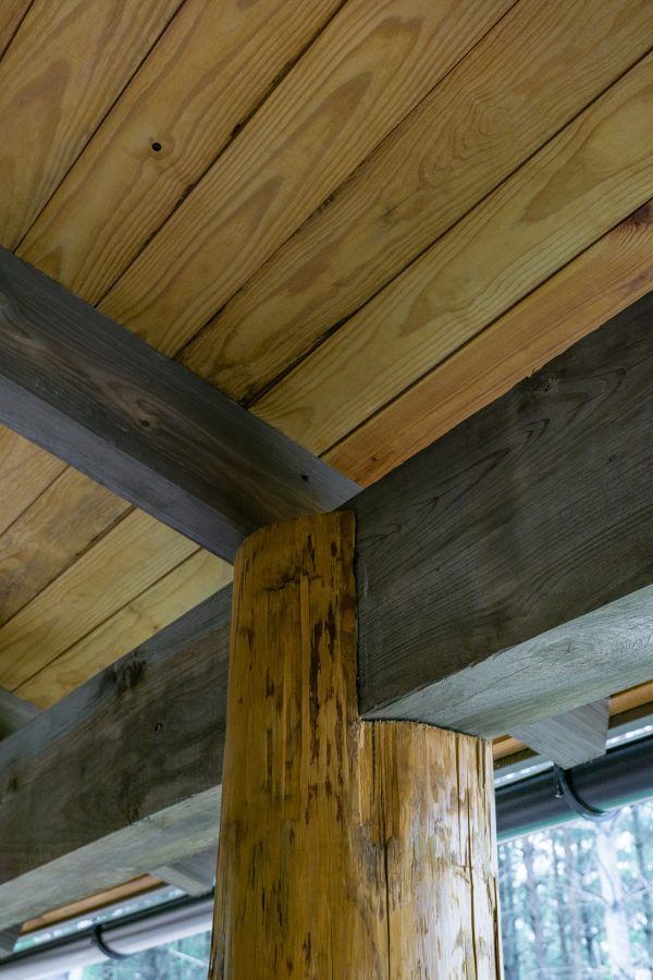 A close up of a wooden ceiling with a log in the middle.