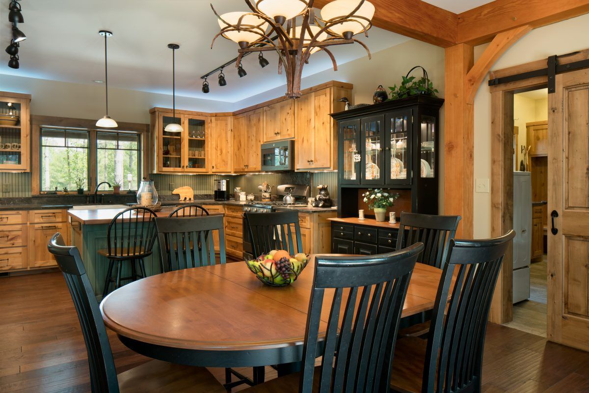 A kitchen with a table and chairs and a chandelier.