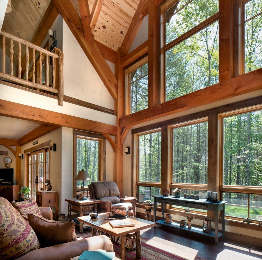 A living room with lots of windows and trees in the background.