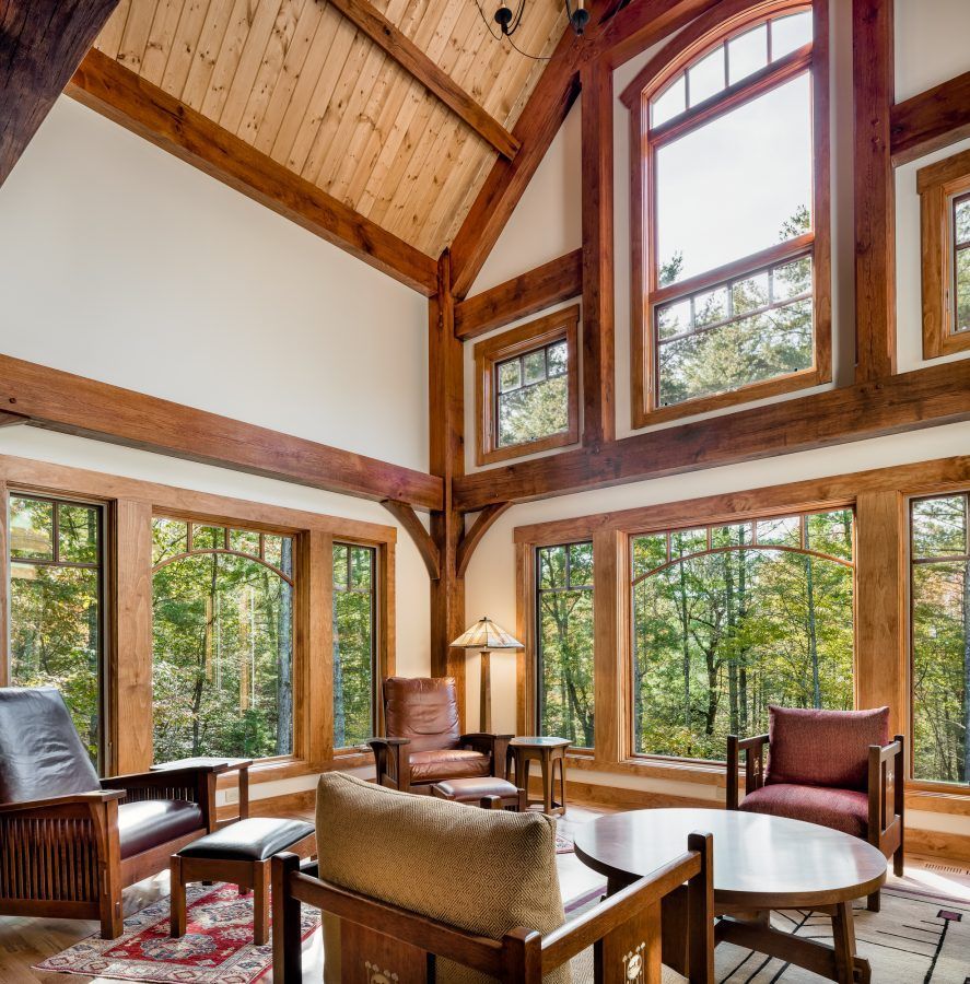 A living room with lots of windows and wooden furniture.