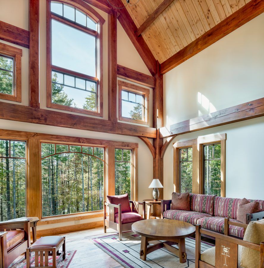A living room with a vaulted ceiling and lots of windows.