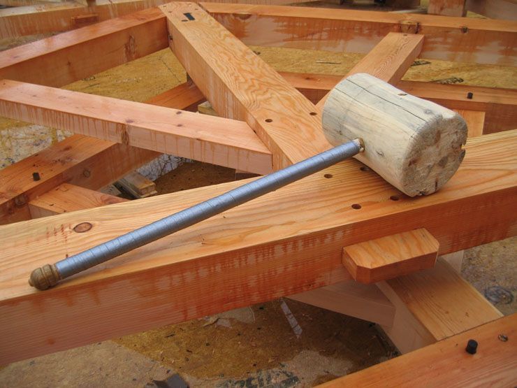 A wooden hammer is sitting on top of a wooden structure.