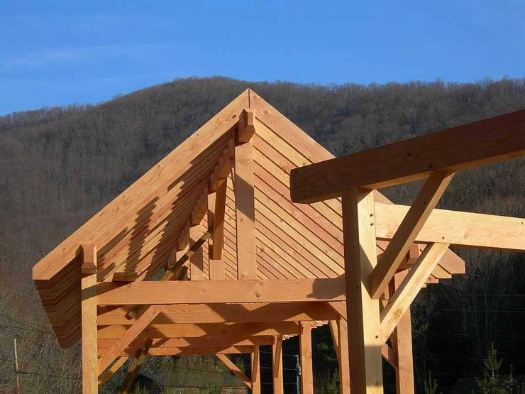 A wooden structure under construction with mountains in the background.