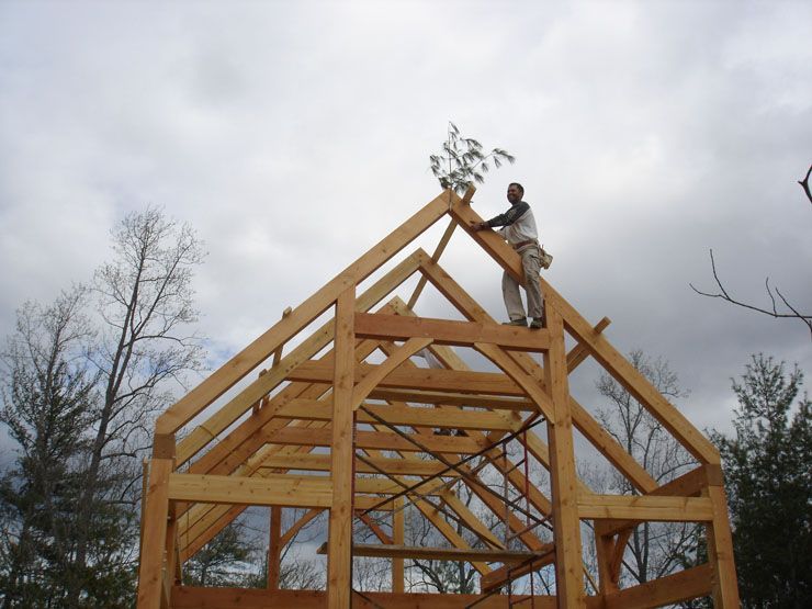 A man is standing on top of a wooden structure.