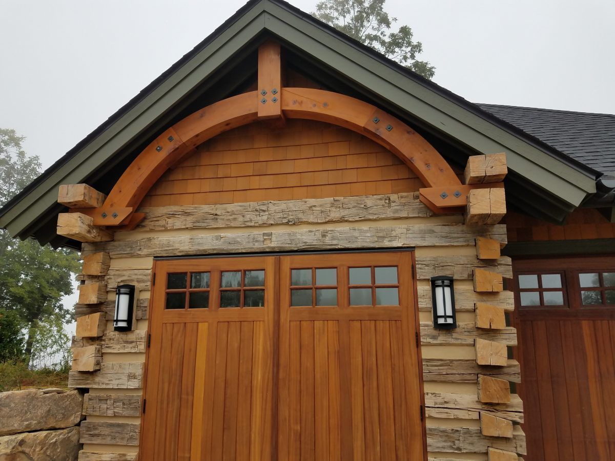 A wooden garage door with a green roof.