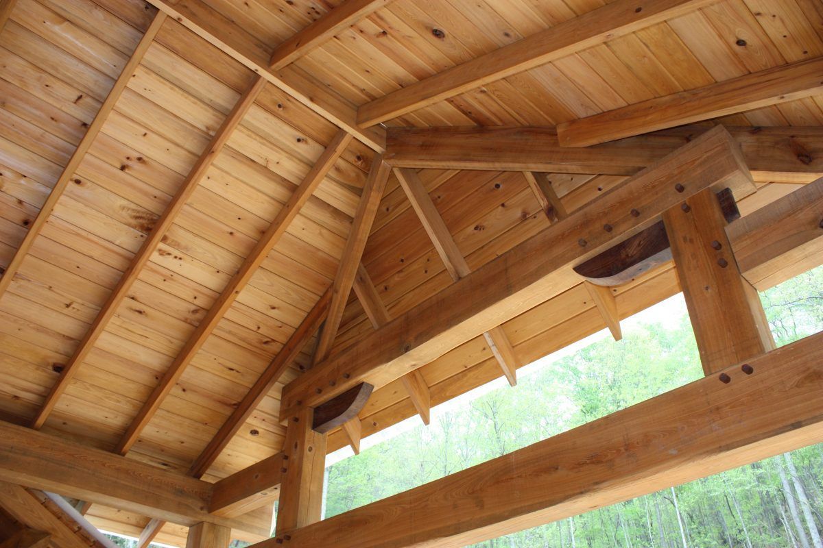 The ceiling of a wooden structure with a lot of beams.