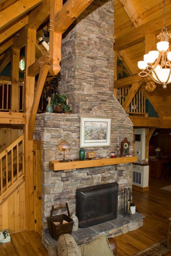 A living room with a large stone fireplace.
