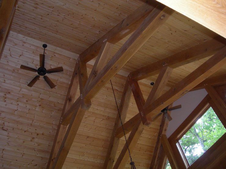 A wooden ceiling with a ceiling fan hanging from it.