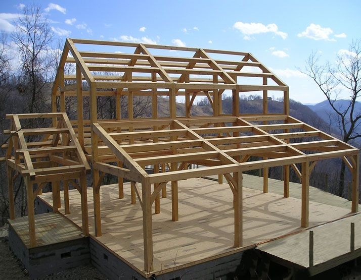 A large wooden structure is being built in the mountains.