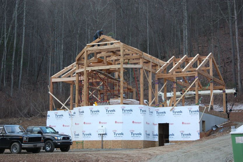 A truck is parked in front of a building under construction.