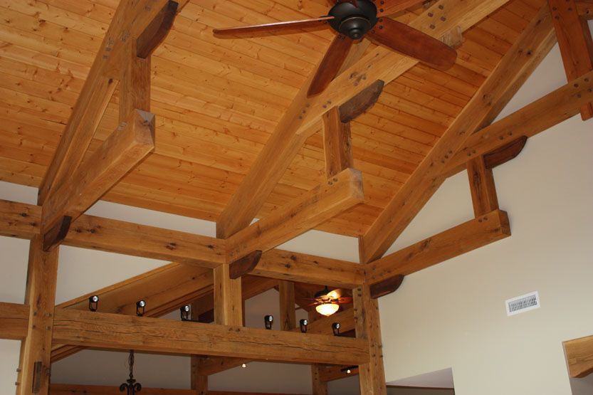 A living room with a wooden ceiling and a ceiling fan.