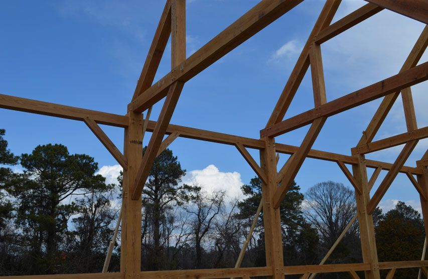 A wooden structure under construction with trees in the background.