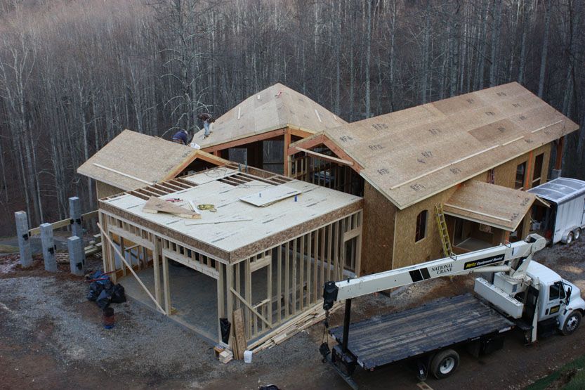 An aerial view of a house under construction with a truck parked in front of it.