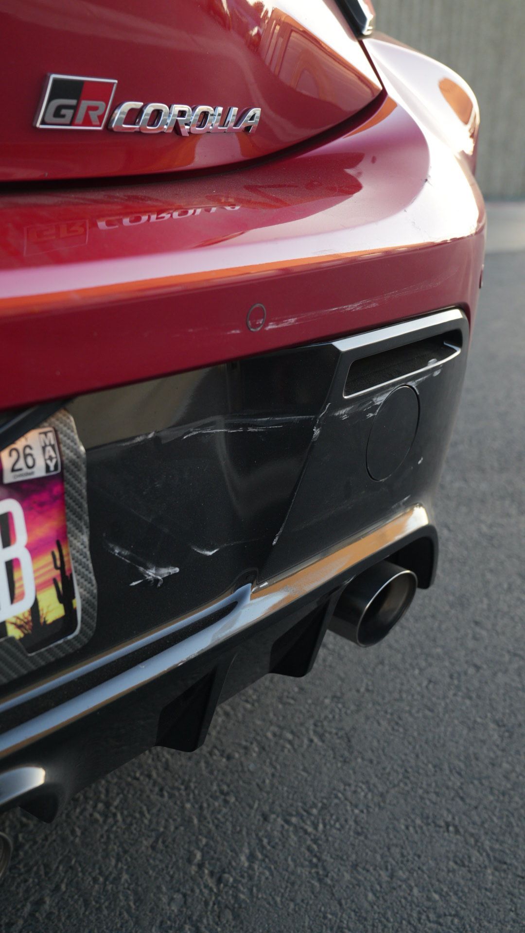Rear of a red Toyota GR Corolla with a black bumper and dual exhaust pipes