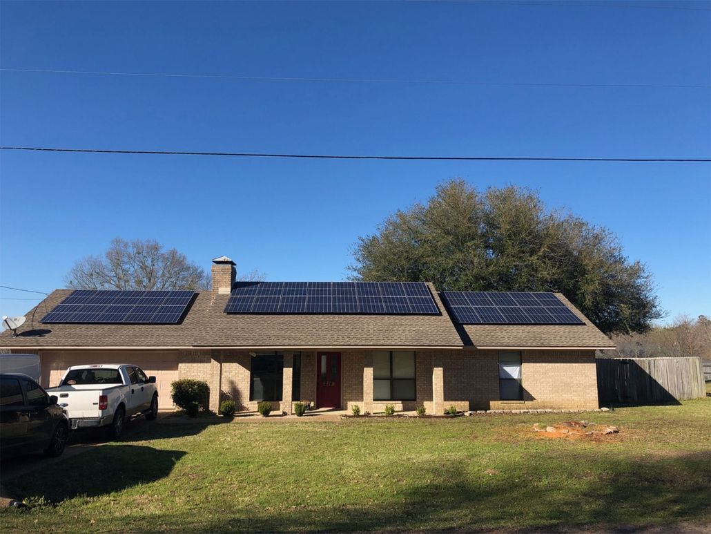 Single-story house with solar panels on the roof and a white truck parked in the driveway.