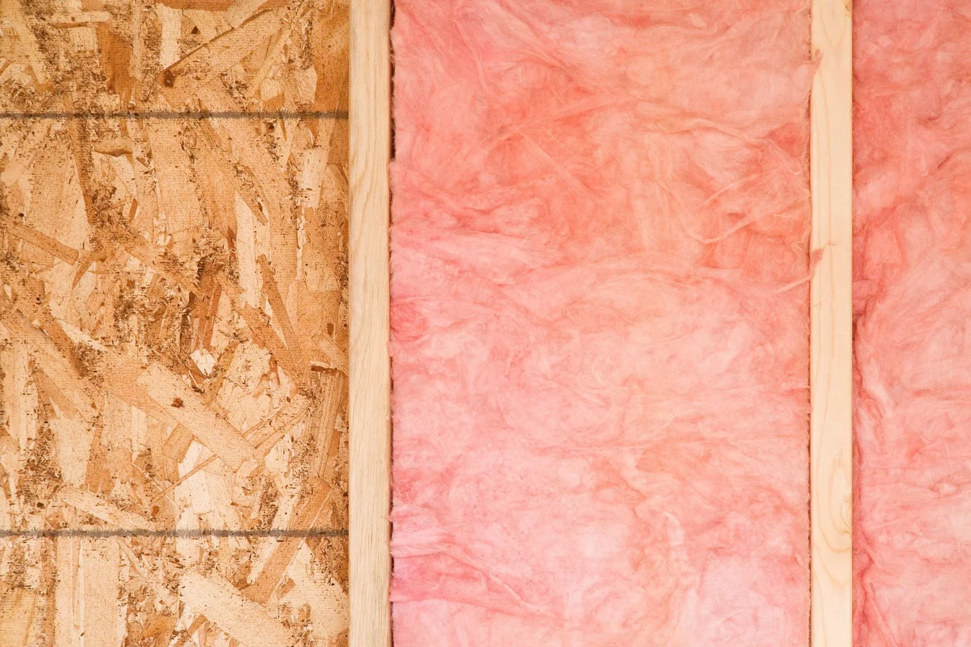 Interior wall under construction showing plywood and pink insulation.